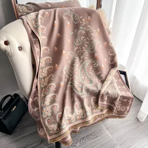 Paisley pattern cashmere-like pashmina shawl with fringes draped on an armchair