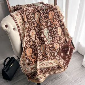 Retro paisley faux cashmere shawl with tassels draped on an armchair in a cozy interior