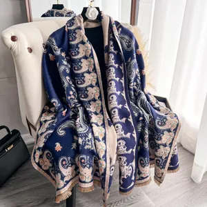Navy blue paisley pattern pashmina shawl with fringes draped on a cream chair