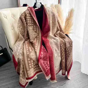 Dettaglio di uno scialle jacquard paisley con tessuto spesso e frange su sedia bianca