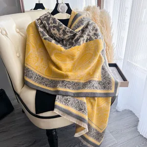 Dettaglio della sciarpa effetto cashmere giallo e grigio con motivo paisley e frange