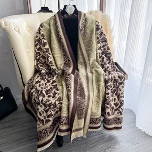 Dettaglio del motivo floreale paisley boho e frange su scialle morbido effetto cashmere