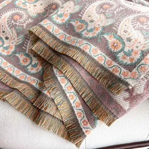 Close-up of paisley pattern knit shawl with colorful fringes and soft textured weave
