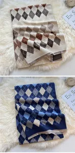 Detail of vintage geometric plaid scarves with soft fringe edge on white plush carpet