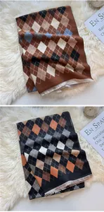 Close-up of geometric argyle knit scarves with fringe edges in coffee and orange tones