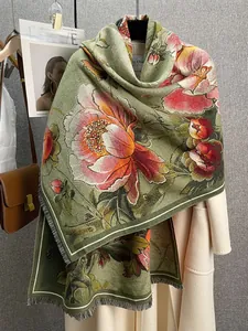 Detail van een bloemencashmere sjaal met olijfgroene basis en franjes aan de rand