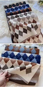Detail of argyle knit scarf featuring soft fringe edges and multi-color diamond patterns