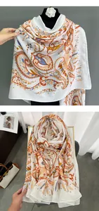 Dettaglio del motivo paisley sulla sciarpa in cotone e lino con accenti arancio e blu