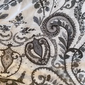 Dettaglio ravvicinato del motivo paisley grigio su sciarpa in cotone e lino