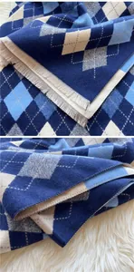Detail of classic argyle pattern and fringe edges on a soft navy blue winter scarf