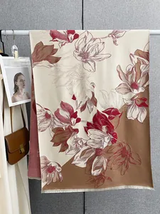 Dettaglio della sciarpa floreale in cashmere con motivi di magnolia e bordi a frange