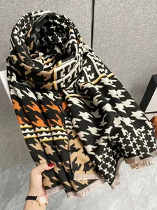 Dettaglio della sciarpa in cashmere con motivo pied-de-poule e frange corte morbide