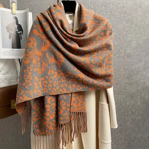 Dettaglio di sciarpa in maglia con stampa leopardata e floreale con frange arancio e grigio
