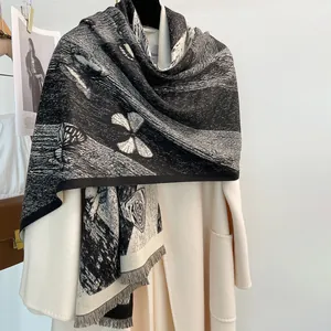 Sciarpa con stampa a farfalla bianca e nera con frange indossata su cappotto bianco