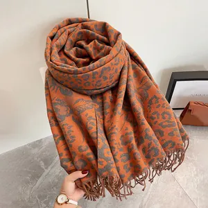 Dettaglio della sciarpa jacquard leopardata invernale in arancione con lunghe frange