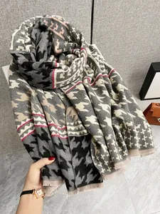 Dettaglio di sciarpa in cashmere pied-de-poule con frange e accenti geometrici rosa