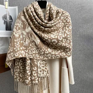 Dettaglio della trama leopardata jacquard e frange di un caldo scialle invernale