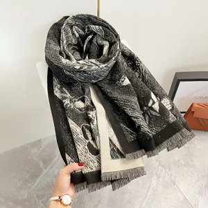 Dettaglio del motivo jacquard a farfalla e frange sottili su uno scialle nero e bianco