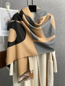 Dettaglio sciarpa in cashmere bicolore spessa con nappe su un cappotto bianco