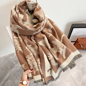 Dettaglio di una sciarpa spessa tipo cashmere con jacquard a gatto e frange