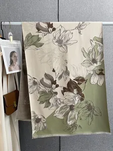 Dettaglio di una sciarpa in finto cashmere con motivi a magnolia e bordi con frange