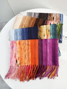 Dettaglio ravvicinato di sciarpe a righe sfumate colorate con morbide nappe su bianco