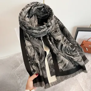 Dettaglio della sciarpa floreale in bianco e nero con bordi a frange delicate