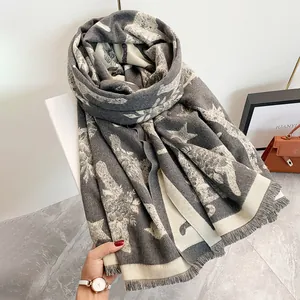 Dettaglio dello scialle in cashmere grigio e beige con motivi di cavalli e frange