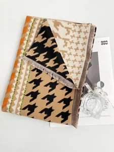 Dettaglio della trama pied de poule con accenti colorati e frange morbide sui bordi