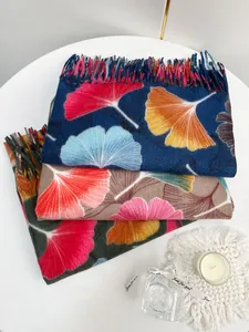 Close-up of winter scarves with maple leaf patterns and fine tassel edge details