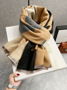 Dettaglio della sciarpa in maglia color block con frange riposta in una scatola regalo bianca