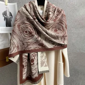 Elegante scialle jacquard floreale marrone e bianco con frange su cappotto di lana