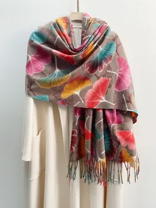 Detailed view of autumn ginkgo leaf print scarf with colorful fringe on cashmere blend