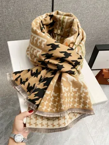 Dettaglio della sciarpa pied-de-poule effetto cashmere con frange su scatola regalo