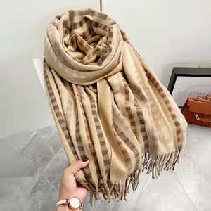 Détail d'une écharpe à carreaux rayés avec texture douce style cachemire et bords frangés