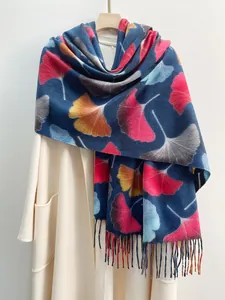 Close-up of navy blue scarf with colorful maple leaf prints and handmade fringe details