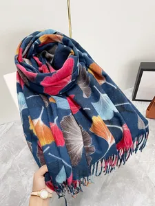 Close-up of maple leaf print scarf featuring soft wool-like texture and tassel fringe edges
