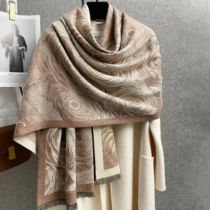 Dettaglio di elegante sciarpa bicolore effetto cashmere con motivo jacquard e frange fini