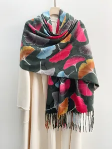 Detailed texture of maple leaf printed scarf with tassels on a white coat
