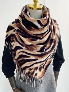 Dettaglio della morbida sciarpa in finto cashmere con stampa tigrata e frange