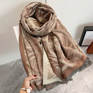 Dettaglio dello scialle autunnale in cashmere con motivi a foglia e bordi con frange
