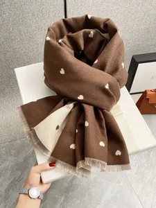 Dettaglio del motivo a cuore e dei bordi sfrangiati sulla calda sciarpa in cashmere