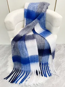 Dettaglio di sciarpa in mohair a quadri blu e grigi con morbide frange sull'estremità