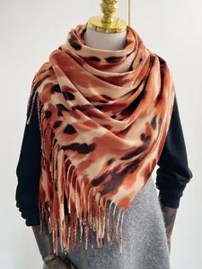 Dettaglio di scialle spesso simil-cashmere con stampa leopardata e rifiniture con frange