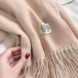 Elegante sciarpa lunga in simil cashmere a tinta unita con frange ed etichetta