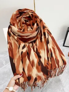 Dettaglio di sciarpa leopardata spessa con frange morbide e texture tipo cashmere