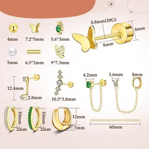 Set de pendientes de latón dorado con mariposa, perlas y circonitas sobre fondo rosa