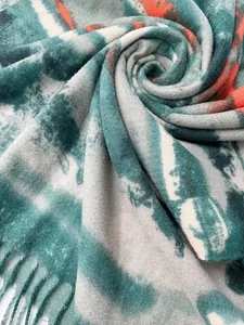 Dettaglio ravvicinato della sciarpa sfumata con motivi tie-dye e eleganti frange morbide