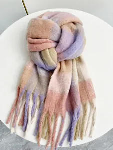 Dettaglio della morbida sciarpa in maglia mohair con sfumature arcobaleno e lunghe frange
