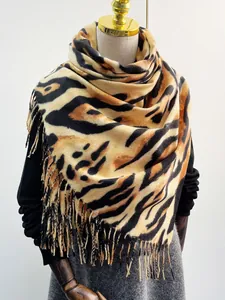 Dettaglio della trama leopardata e delle frange fitte su scialle in finto cashmere